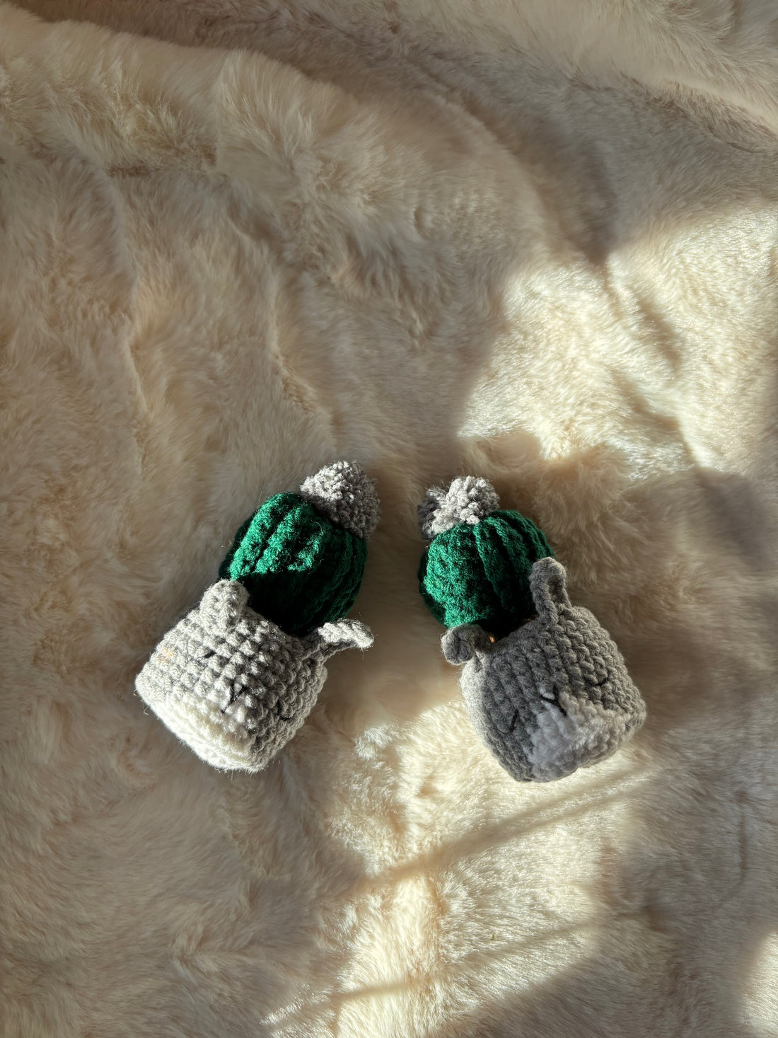 Pair of mini crochet cacti in grey cat pots, top view