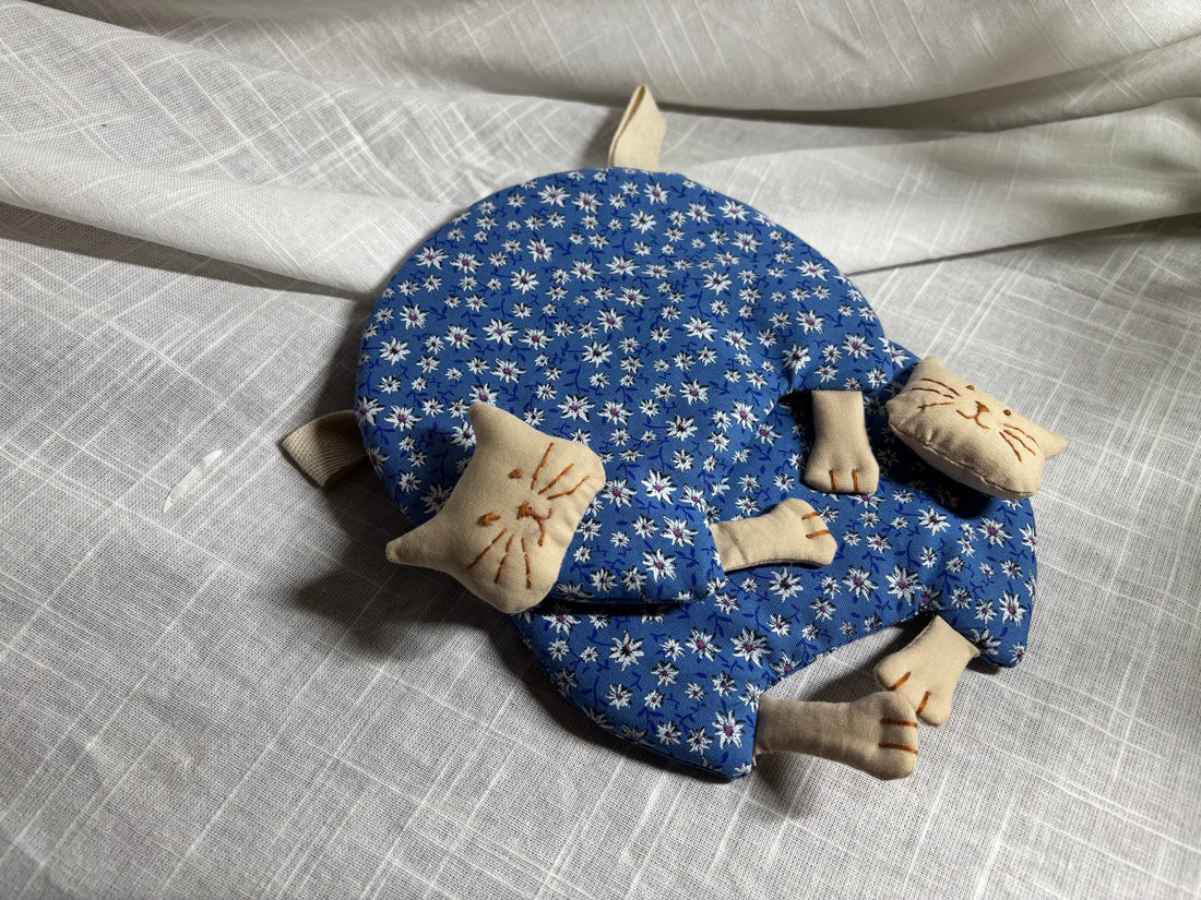 Hand-sewn cat potholder curled up like a sleeping cat