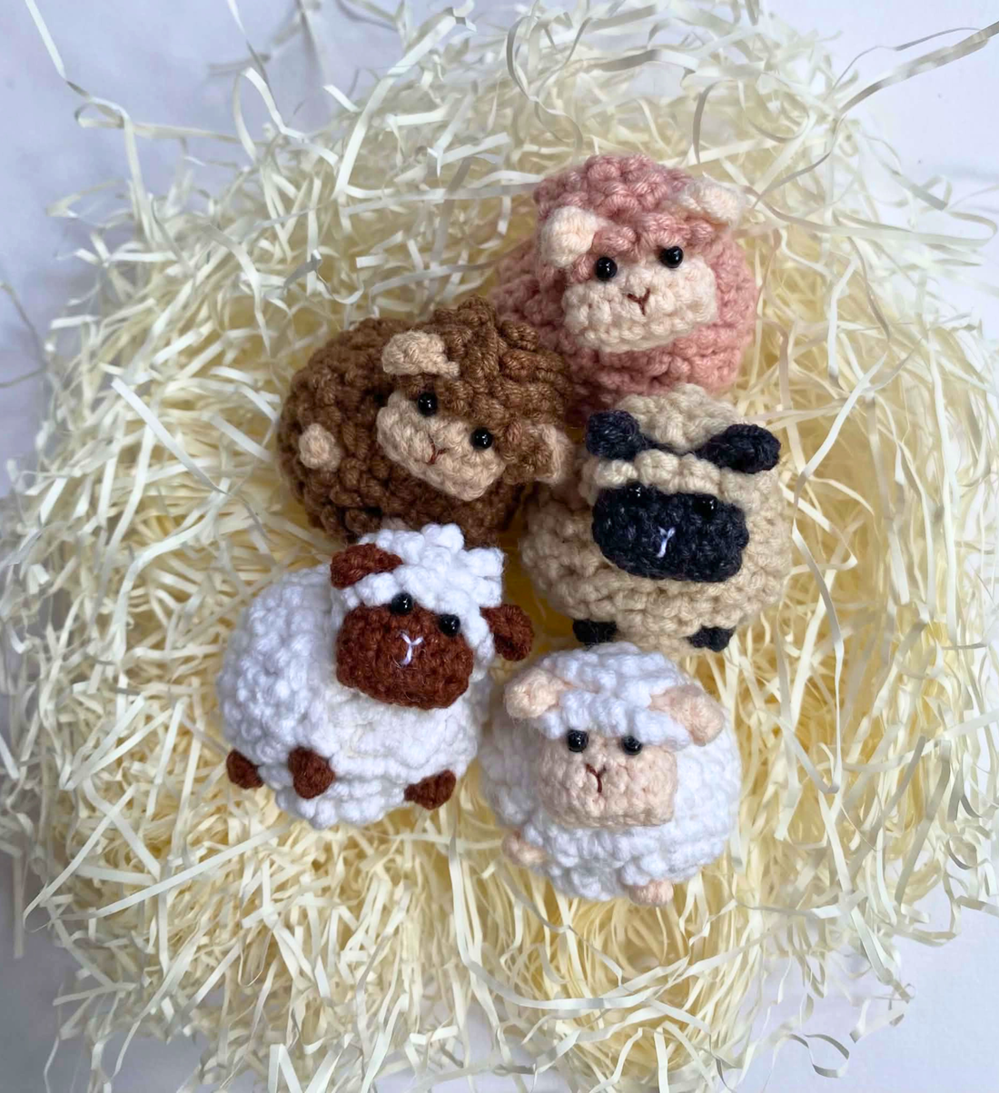 Five crochet sheep bomboniere nestled in paper shred