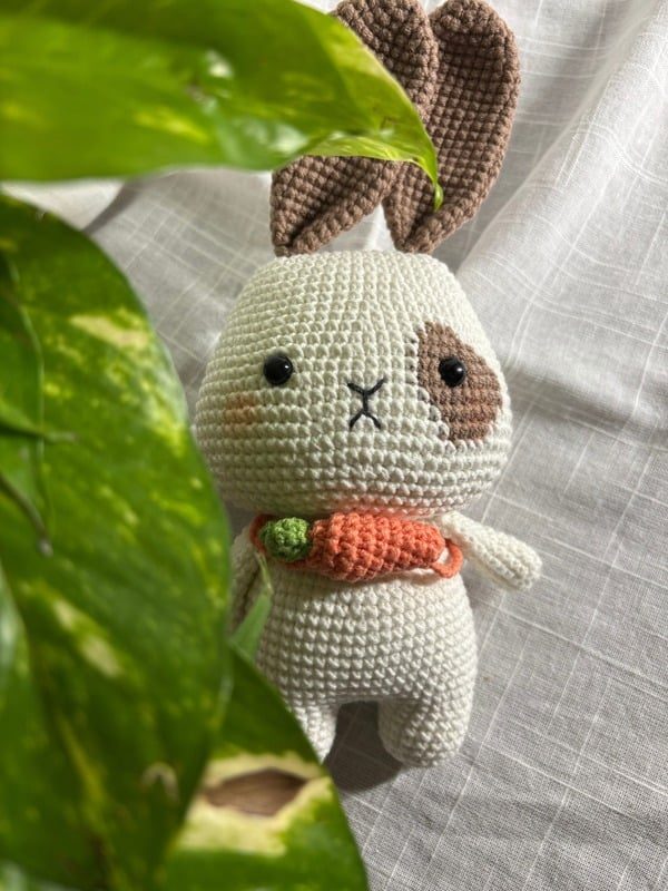 Crocheted cream bunny holding a carrot bag — Full view