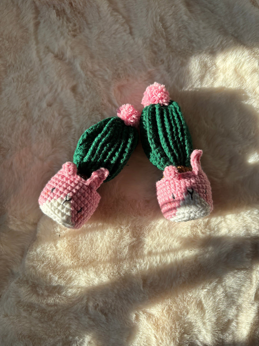 Pink bunny pot crochet cacti lying on soft fur