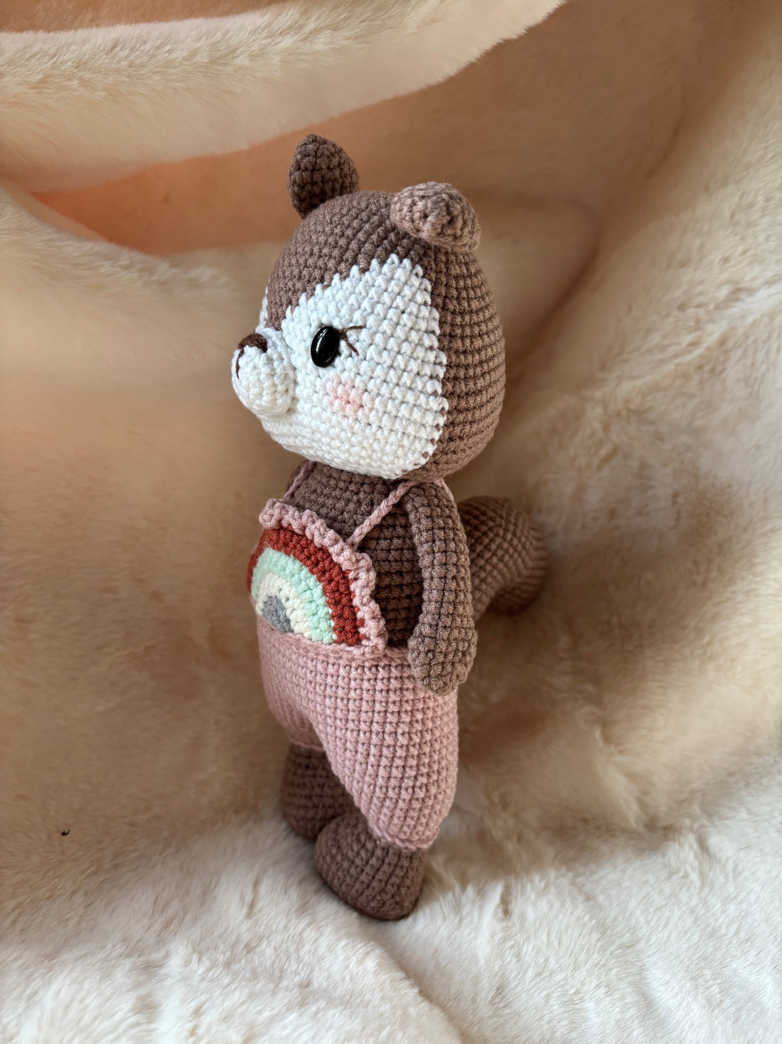 Crochet squirrel in overalls, three-quarter view