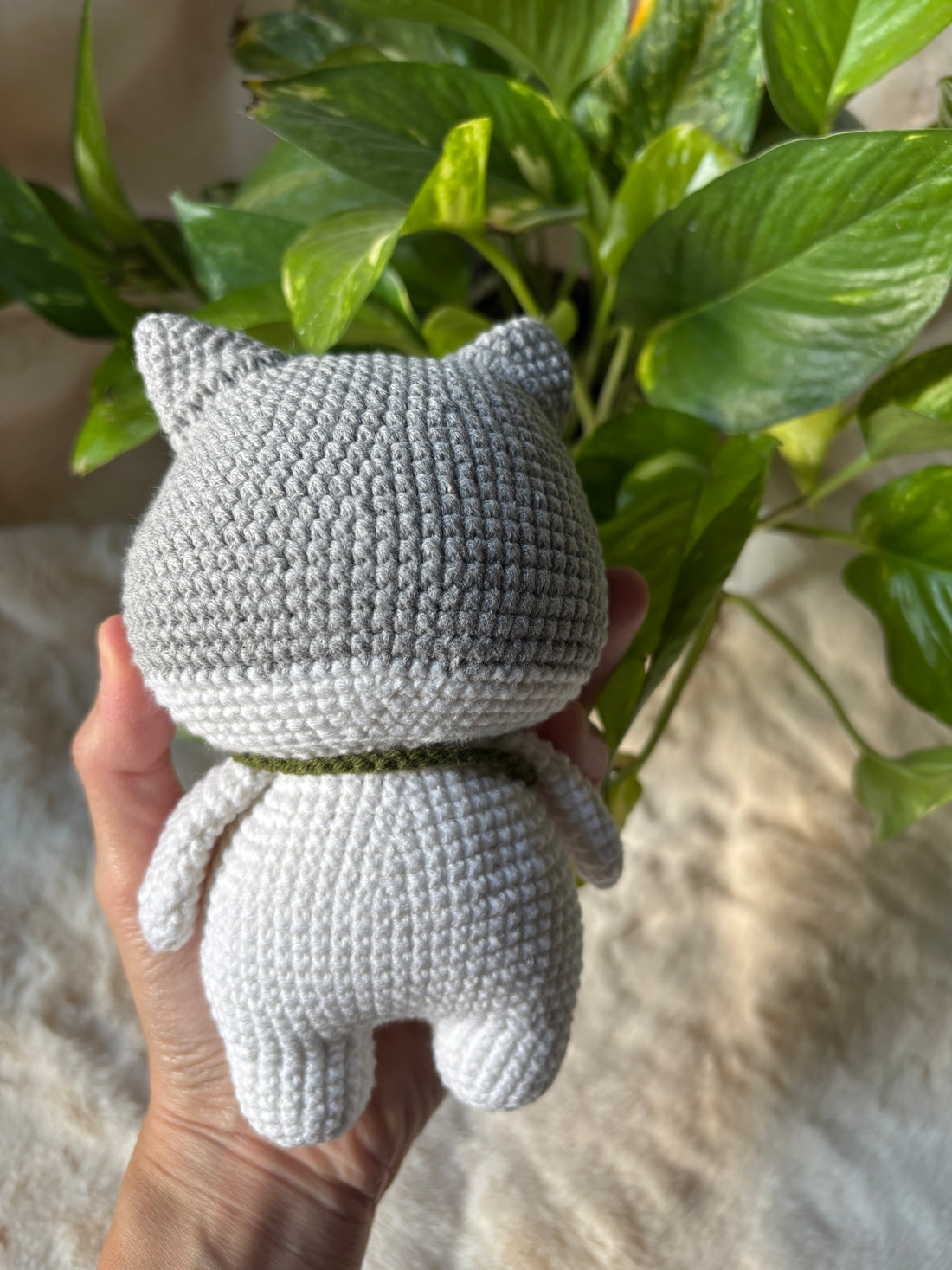 Crochet grey cat back view held in a hand