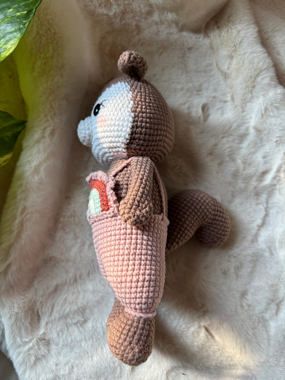 Crochet squirrel side view with tail and pink overalls