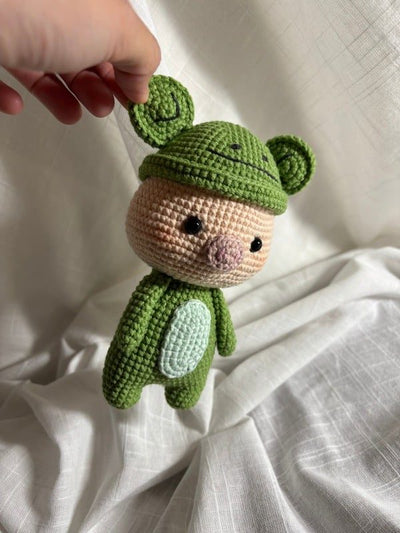 Crocheted piglet dressed as a frog