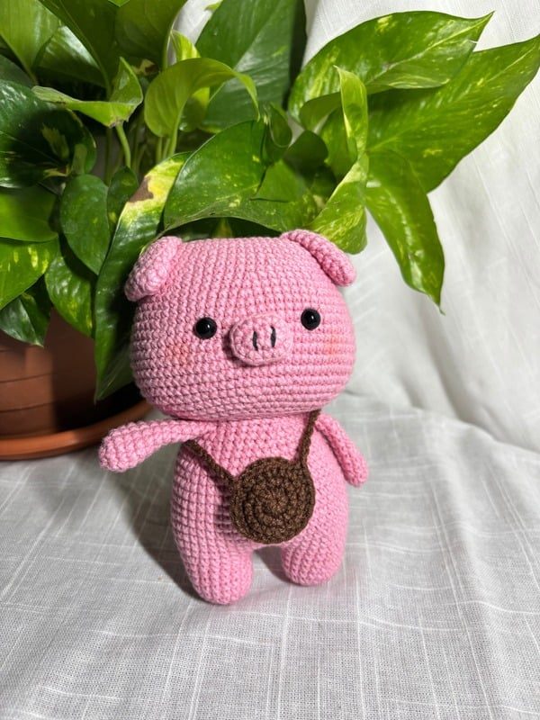 Crocheted pink piglet with a crossbody bag